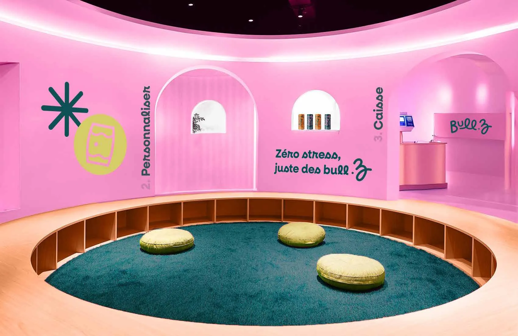 Intérieur rose du pop-up store Bull’Z : salle arrondie, tapis vert sarcelle, arches et signalétique de la marque.